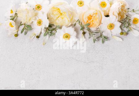 Flat lay of delicate white roses and anemones on textured gray background with free space. For wedding invitations, Mother s Day, Easter, branding Stock Photo