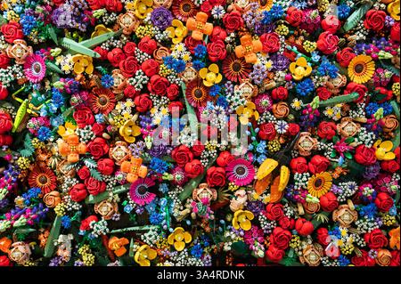 Colorful Lego plastic building blocks arranged in a floral pattern, creating a vibrant and playful background Stock Photo
