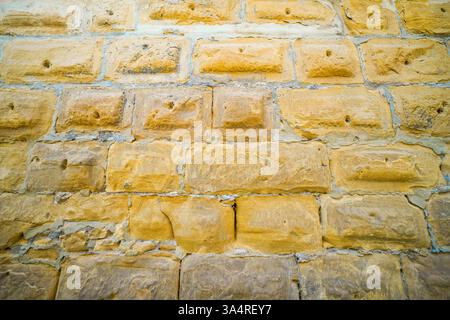 Old castle wall made of blocks. Background and natural building materials. Stock Photo