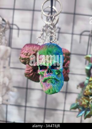 Objects keychains in form of skull of a man, models of toys printed on 3D printer from multi-colored molten plastic hanging on chain. Concept 3D Printing. New modern 3D Printing additive technology Stock Photo