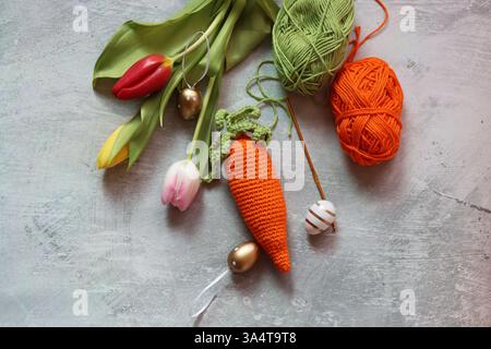 Easter still life with tulips, eggs and crocheted carrot. Stock Photo