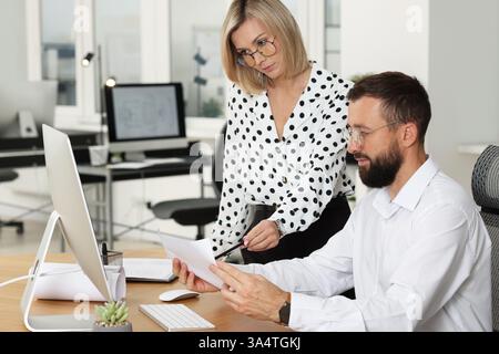 Technicians making digital engineering drawing on computer at desk in office Stock Photo