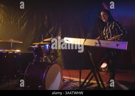 Musician passionately singing and playing keyboard on stage during live performance, copy space Stock Photo