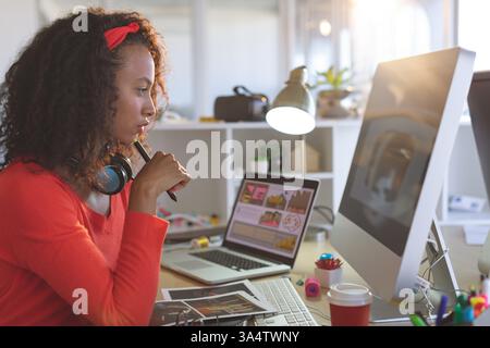 Creative woman working at desk with computer and laptop, focusing on design, copy space Stock Photo