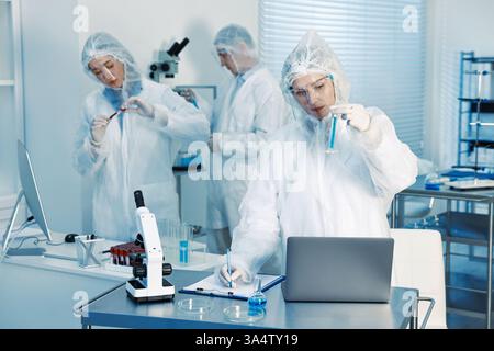 Scientists working with computers and samples in laboratory Stock Photo