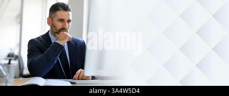 Middle aged businessman in office deep in thought about project success Stock Photo