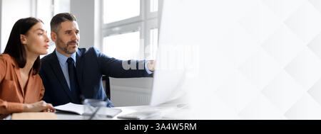 Professionals european woman and man financial accountant and manager working in office, looking at computer screen Stock Photo