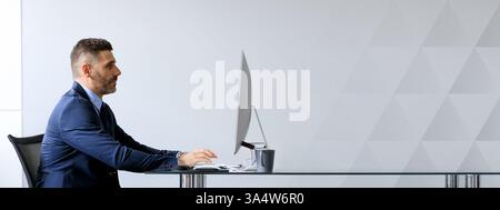 Middle aged businessman working diligently at his office desk Stock Photo