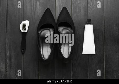 Shoes, brush and shoe polish on black wooden background Stock Photo