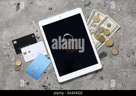 Tablet computer with padlock, credit cards and money on grunge background. Cyber security concept Stock Photo