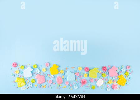 Easter sweets and candies background. High-colored blue flat lay with various Easter chocolate eggs, treats, symbols of easter sheep, bunny, carrot, f Stock Photo