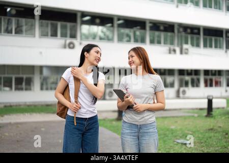 Learning and Academic Exchange. Two students share a moment of collaboration while surrounded by their campus, promoting the importance of education. Stock Photo