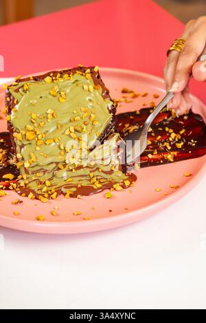 Dubai chocolate cake Knafeh dessert served on a plateat a cafe restaurant. Stock Photo