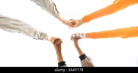 Three young people joining hands, creating a powerful symbol of unity, collaboration, and teamwork Stock Photo