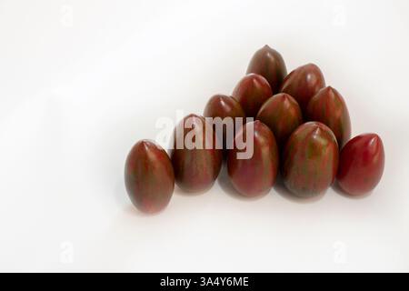 Pile of fresh ripe sweet red striped tomatoes isolated on white background. Stock Photo
