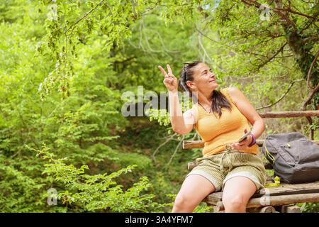 Woman sitting on wooden bench and using smartphone Stock Photo