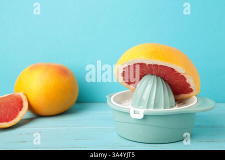 Juicer with freshly squeezed red grapefruit juice,with whole and sliced grapefruit on mint. Top view Stock Photo