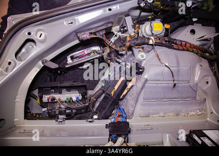 A system of multicolored wiring and various modules in the car's trunk compartment, hidden from the user Stock Photo