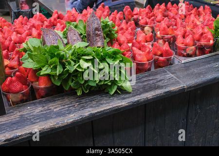 Plastic cups of fresh strawberries on sale with bunches of mint, Borough Market, London Stock Photo