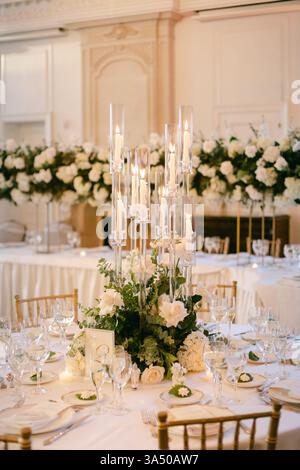 Beautifully set wedding reception table adorned with floral arrangements and stylish candle centerpieces. Stock Photo