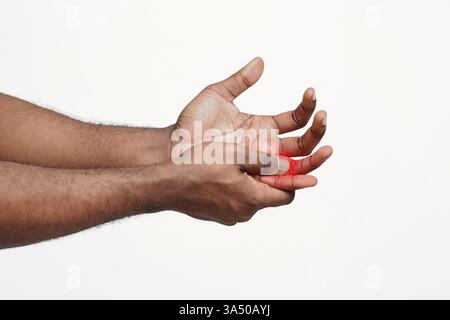 Cropped close-up of a man massaging his painful finger against a white background. Useful for healthcare, pain relief, arthritis, and hand injury topics. Suitable for medical, wellness, and symptom awareness campaigns. Stock Photo