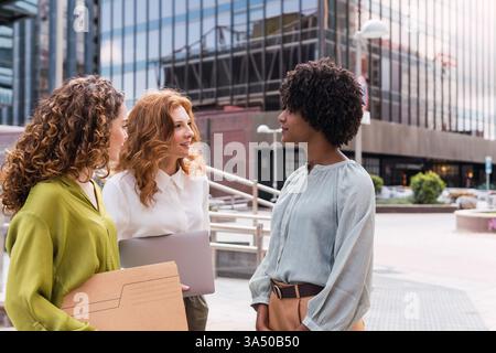 Group of diverse professionals meeting outdoors, collaborating and discussing ideas. The outdoor setting supports teamwork, brainstorming, and business communication themes. Perfect for corporate campaigns, leadership, and startup content. Stock Photo