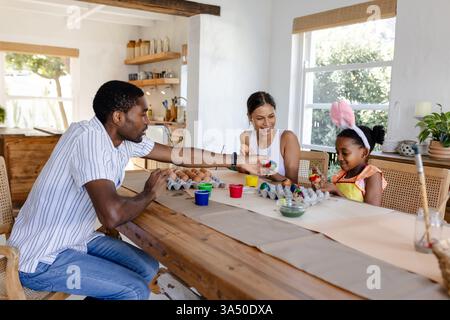 Painting Easter eggs together, African American family having creative time at home Stock Photo