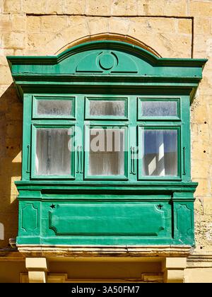 Old green wooden window on the wall of an old house in Malta Stock Photo