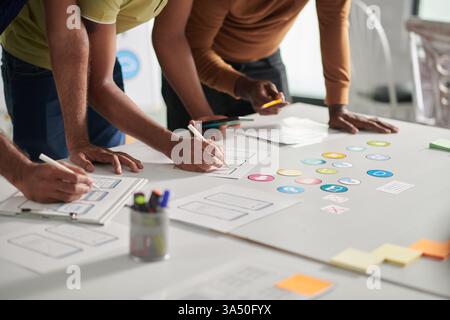 Cropped image of a UX designer working on a set of icons for a new online service. It highlights user interface design, UX and digital product development. Stock Photo