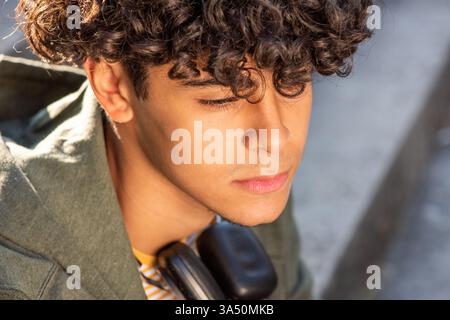 Close up portrait of a thoughtful young North African man. The casual, urban look suits lifestyle and fashion contexts. A compelling headshot for contemporary editorials and profile features. Stock Photo