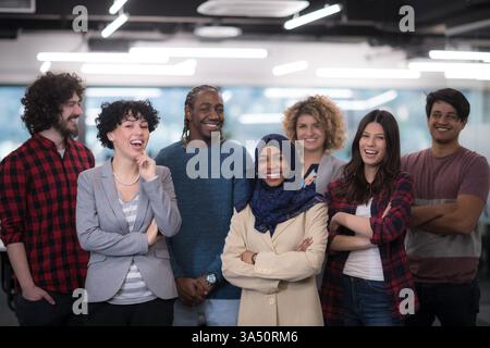 Portrait of a diverse software development team celebrating success at a modern startup. The excited group looks toward the camera, conveying teamwork, innovation, and entrepreneurial energy in a contemporary office. Stock Photo