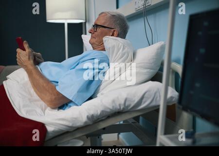 Senior Man Using Smartphone In The Ward Stock Photo