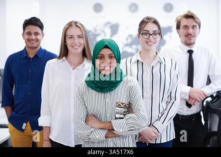 Portrait of a diverse group of software developers in a modern startup office, standing and looking at the camera. This image emphasizes teamwork, diversity in tech, and an energetic workplace. Suitable for technology, innovation, and corporate communications. Stock Photo