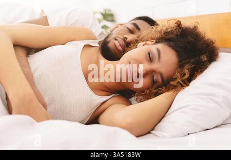 Afro couple hugging while sleeping together in bed, top view Stock ...