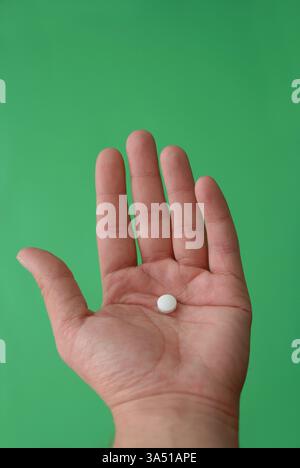 Close-up of pills held in a hand, showcasing tablets and capsules for everyday medications. This image highlights pharmaceutical products and healthcare, suitable for topics on medicine, drugs, and treatment. Ideal for campaigns or articles about medication safety, pharmacy, and health awareness. Stock Photo