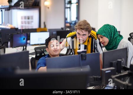 Diverse startup team meeting in a modern open-plan office, featuring an Arabian hijab-wearing woman collaborating with colleagues. The scene emphasizes teamwork, technology, and entrepreneurship. Ideal for business, startup, and diversity campaigns. Stock Photo