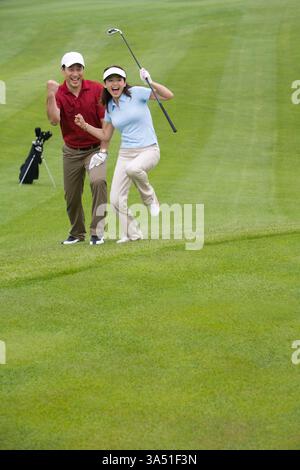 Two Chinese golfers celebrate a great shot on the golf course. An upbeat outdoor leisure image showcasing sport, teamwork, and achievement. Perfect for golfing, sports, and leisure features or campaign visuals. Stock Photo