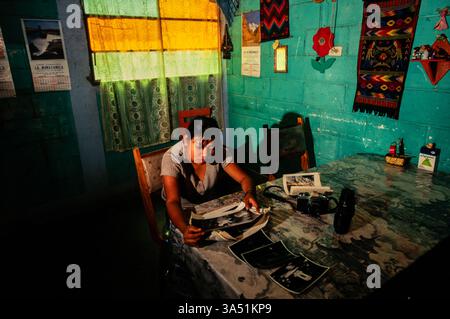 A student with the 'Mari Sol Photo School' at home, looking through her work, Guatemala City, Guatemala. Stock Photo