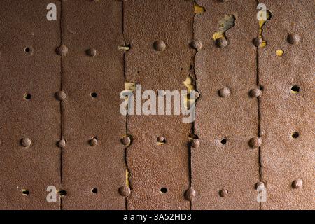 Himeji, Japan - Sep 24 2024, A close-up view of a metal surface consisting of old, rusty, partially destroyed iron sheets with rivets, inside Himeji C Stock Photo