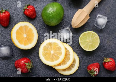 Juicer and ingredients for preparing strawberry lemonade on black background Stock Photo