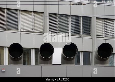 Four large ventilation pipes on a roof edge with an alarm system Stock Photo