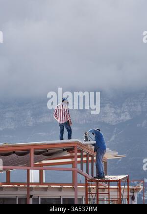 Two workers working on the roof Stock Photo