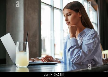 Beautiful woman with laptop is in the bar. Stock Photo