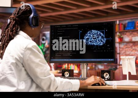 Admin writing code on computer and doing maintenance on artificial intelligence neural networks, listening music. Tech support expert wearing headphones typing on keyboard, doing checkup on AI systems Stock Photo