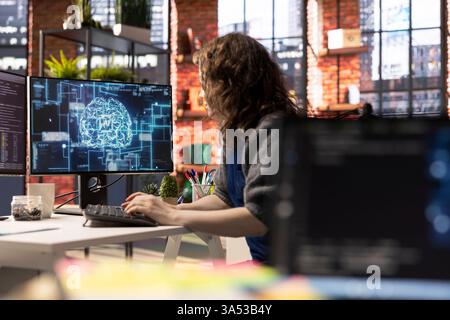 Teleworking developer using computer for artificial intelligence computing through self learning algorithms. Agency IT engineer works with AI deep neural networks on desktop PC. Stock Photo