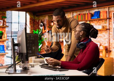 Teamworking startups employees leveraging machine learning technology in office to gain competitive edge. Silicon Valley company colleagues collaborating to do rapid technological advancement Stock Photo