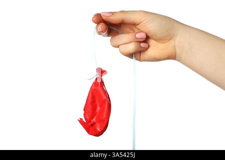 Woman holding popped red balloon on white background, closeup Stock Photo