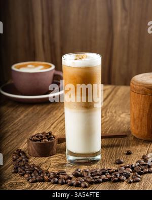 Delicious layered latte coffee drink on wooden table with coffee beans Stock Photo