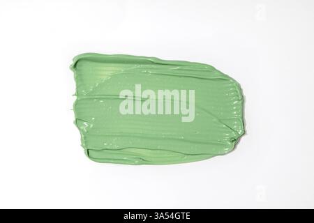 Green mud mask swatch on white background. Close up of cosmetic product smear, concealer, kaolin or green tea mask. Thick texture isolated on white. Stock Photo