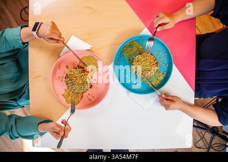 Girl friends eating dubai chocolate kunafa pancakes served at a fancy restaurant cafe. Stock Photo